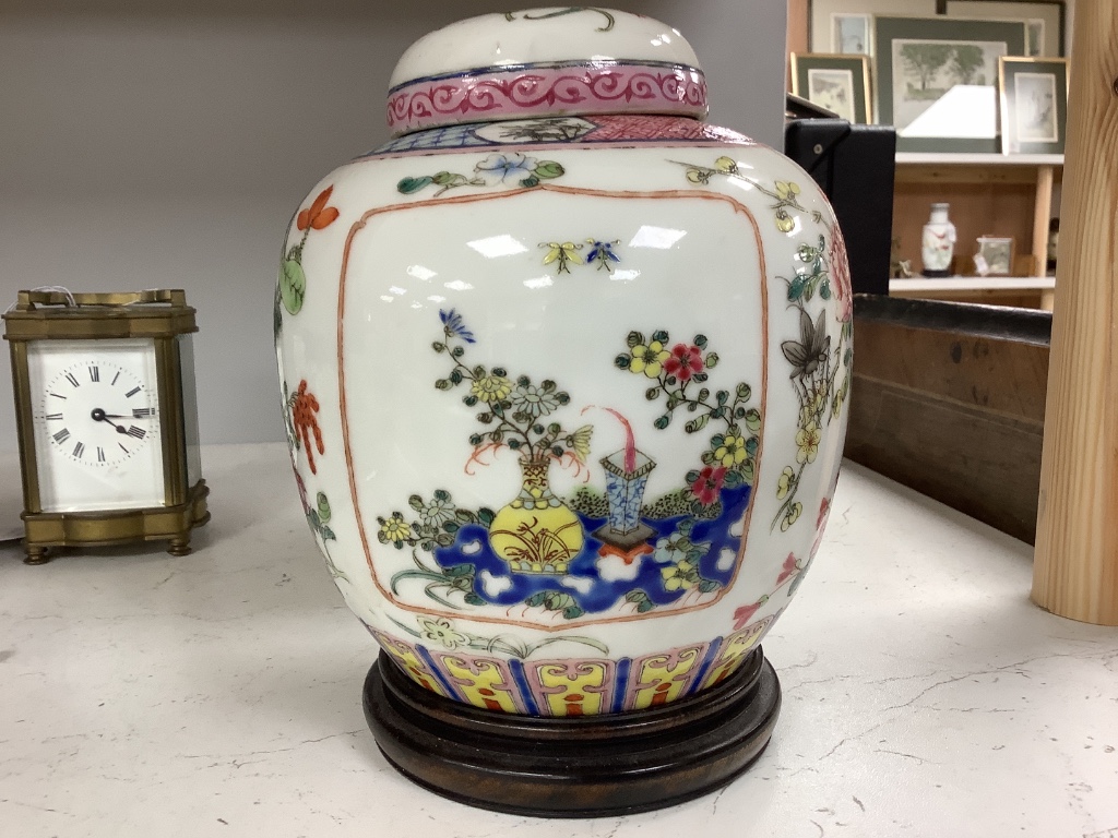 A pair of Chinese famille rose jars and covers, late 19/early 20th century, 15.5cm, on hardwood stands